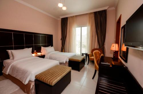 迪拜珊瑚精品别墅酒店的酒店客房设有两张床和一台平面电视。