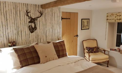 霍尔特Keepers Cottage Guest House的卧室配有一张带鹿头的墙壁床。