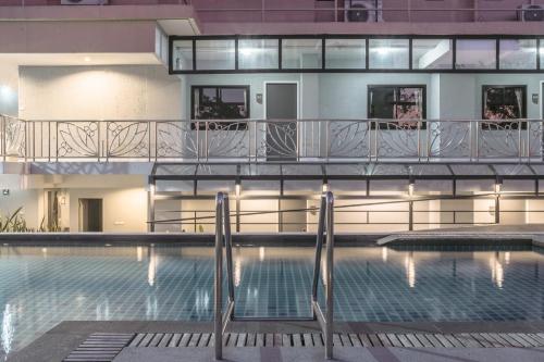 北榄府Carnation Residence的一座带游泳池和阳台的建筑