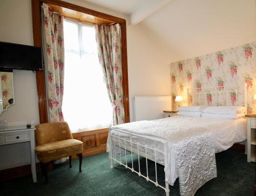 温德米尔避风港酒店的一间卧室设有一张床、一个窗口和一把椅子