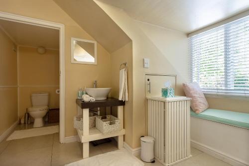 开普敦Little House Villa的一间带水槽和卫生间的浴室以及窗户。