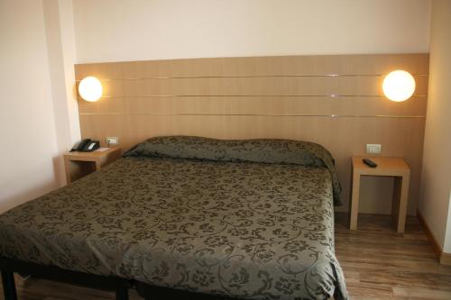 Lentate sul SevesoAlbergo Nardini的一间卧室配有一张床和两张桌子