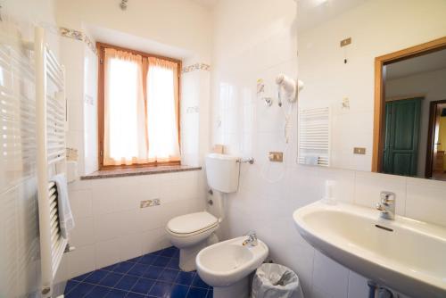 菲乌马尔博Hotel Appennino的白色的浴室设有卫生间和水槽。