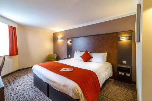 金斯林金斯林品质酒店的酒店客房设有一张带红色毯子的大床
