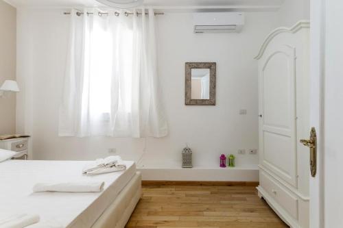 卡利亚里Domus Karalis的白色的卧室设有一张大床和一个窗户
