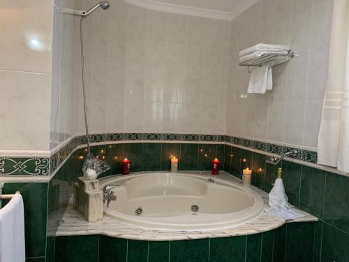 安特克拉拉谢拉酒店的浴室设有大浴缸,内配蜡烛