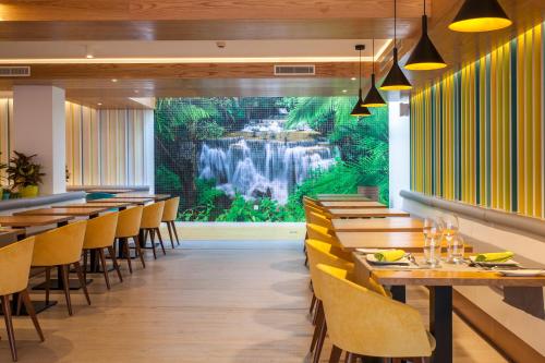 美洲海滩Vanilla Garden Boutique Hotel - Adults Only的餐厅墙上挂有瀑布壁画
