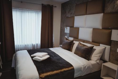 布鲁塞尔Hôtel onyx expo的一间卧室配有一张大床和两条毛巾