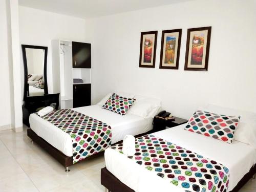 辛塞莱霍Hotel Cosmos Sincelejo的一间带两张床和一张沙发的卧室