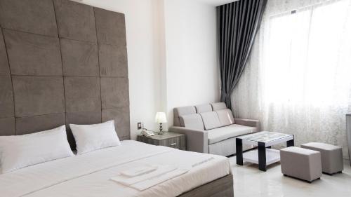 胡志明市White Diamond Hotel - Airport的配有一张床和一把椅子的酒店客房