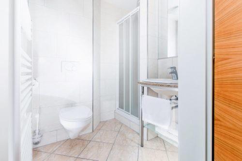 格莱斯多夫Rasthaus zum Dokl的白色的浴室设有卫生间和水槽。