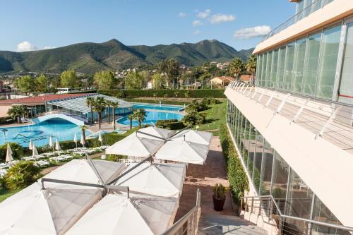 洛阿诺洛阿诺田园酒店的享有带遮阳伞的度假村游泳池的顶部景致
