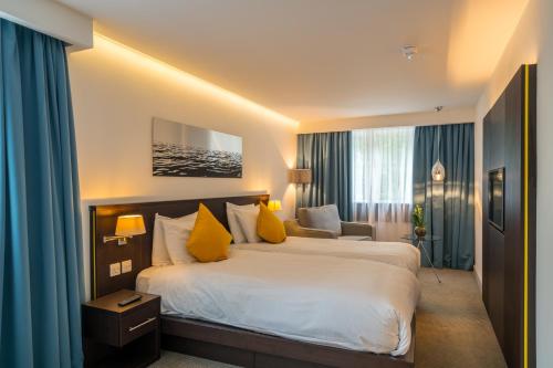 伦敦鹈鹕伦敦公寓酒店的酒店客房配有一张带黄色枕头的大床