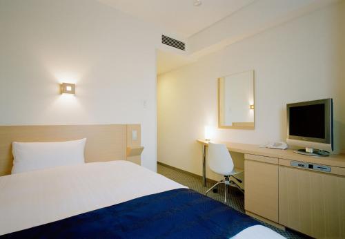 鹿儿岛鹿儿岛乌比客酒店的酒店客房,配有床和电视