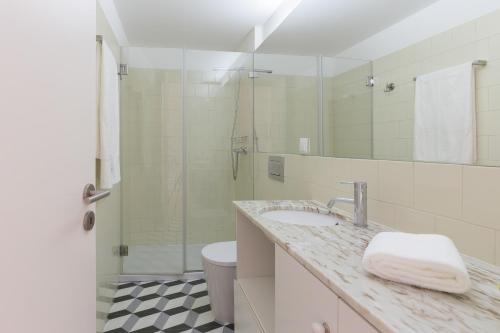 波尔图Colorful Stunning Sunlit Flat by Host Wise的一间带水槽、卫生间和镜子的浴室