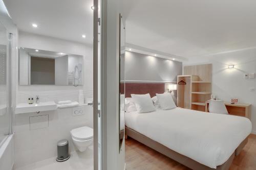 楠泰尔拉曼帝业酒店的一间带白色床的卧室和一间浴室