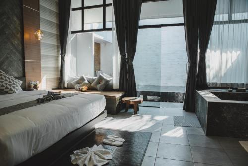 清迈Arun Dara Villa的一间卧室配有一张床、一个浴缸和一个水槽