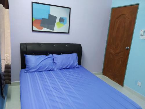 Kampong MerbokDZe Homestay Singkir Genting的一间卧室配有一张带蓝色棉被的床
