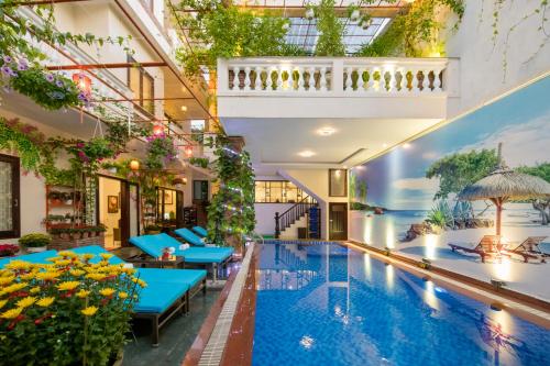 会安Pham Gia Boutique Villa的一座设有蓝色桌子的建筑中的室内游泳池