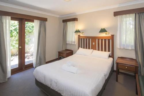玛格丽特河玛格丽特河度假村的卧室设有白色大床和窗户。