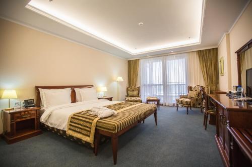 阿克套里海海滨皇宫大酒店的酒店客房设有一张大床和一张书桌。