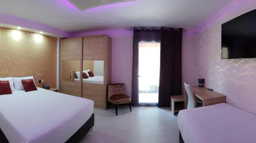 卡斯泰勒雅卢L'Hôtel du Lac Casteljaloux的酒店客房设有两张床和电视。