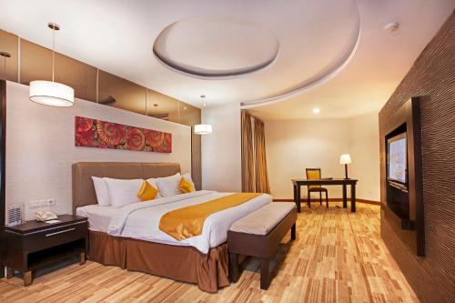 坤甸ASTON Pontianak Hotel and Convention Center的酒店客房设有一张大床和一台电视。