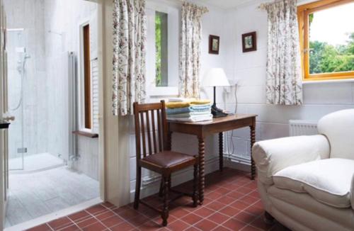 韦克斯福德Seaside Cottage的客房设有一张桌子、一把椅子和一张沙发