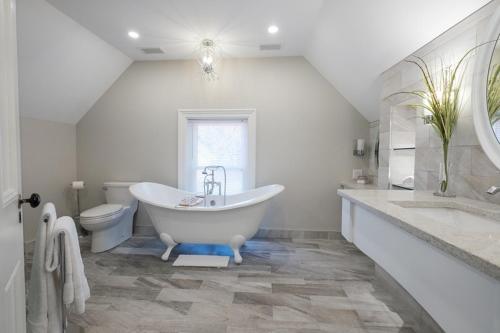 WestportThe Victorian Luxury Suites的白色的浴室设有浴缸和卫生间。