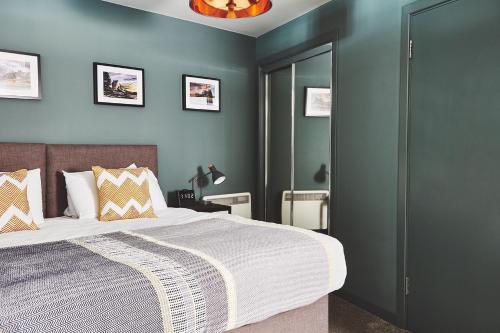 奥本The Ranald Apartments的一间卧室配有一张带蓝色墙壁的大床
