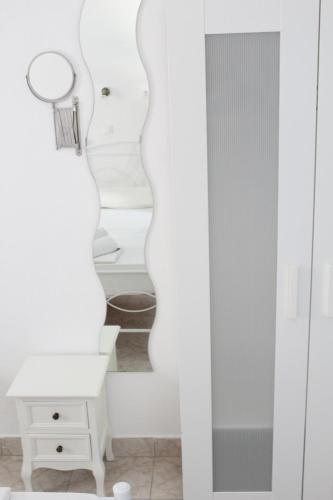 伊奥斯乔拉伊奥斯蓝色地平线公寓 的白色的客房设有镜子和白色的梳妆台