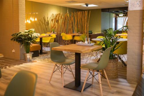 东福尔讷马里昂住宿加早餐酒店的餐厅配有一张桌子和椅子,还有黄色的椅子