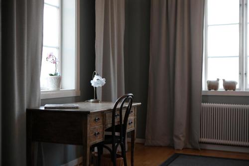 胡斯克瓦纳Slottsparken Motel的一张桌子,椅子和一朵花放在房间里