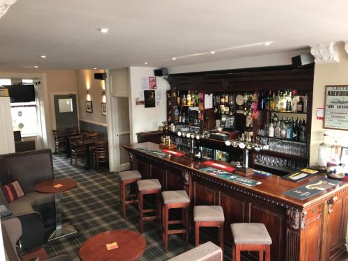 阿伯道尔Aberdour Hotel, Stables Rooms & Beer Garden的酒吧里酒吧里,有一大堆酒吧凳