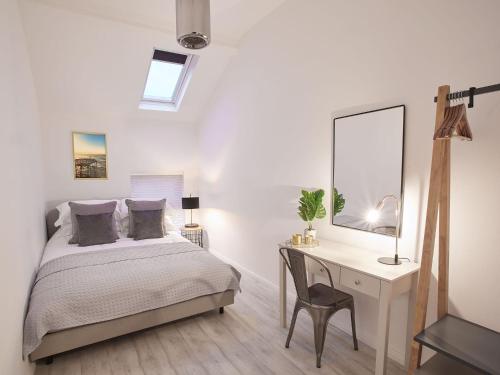 滨海索尔特本Host & Stay - The Surfer's Loft Apartment的一间卧室配有一张床和一张带镜子的书桌