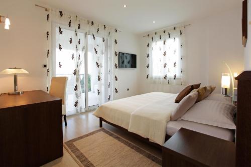 波尔挪拉别墅旅馆的一间卧室设有一张床和两个大窗户