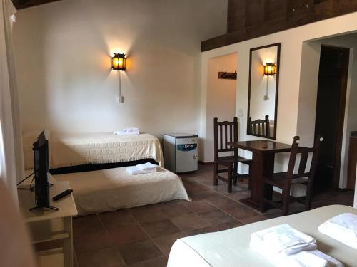 格塞尔镇HOSTERÍA SAJONIA的客房设有两张床、一张桌子和镜子