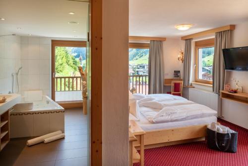 莱赫阿尔贝格美丽达豪斯酒店的一间卧室设有一张床和一个阳台