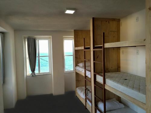 萨尔瓦多Mar à Vista Hostel的客房设有双层床和窗户。