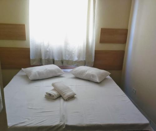 陶巴特Acomodações Silvestre的一张带两个枕头的床和窗户