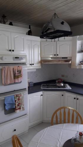 基督教堂市Sue's Homestay的厨房配有白色橱柜和炉灶烤箱。