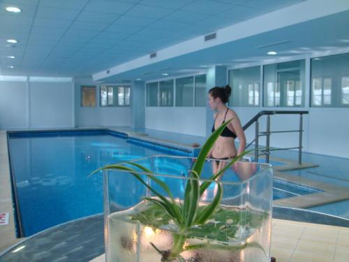 科斯泰内茨Constantzia Balneohotel的站在游泳池旁的比基尼的女人