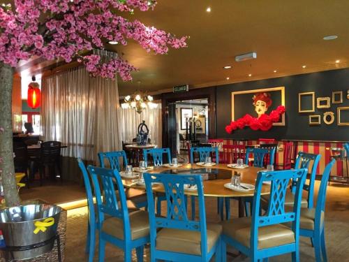 马六甲蜜梦酒店的一间带桌子和蓝色椅子的用餐室