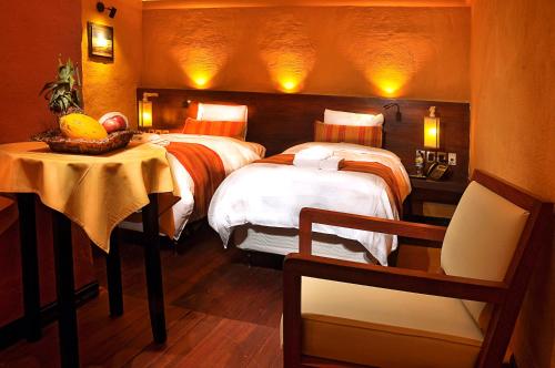 乌尤尼花园乌尤尼酒店的一间卧室配有两张床和一张桌子及椅子