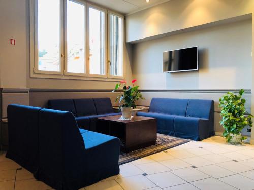 锡尼亚德尔菲娜酒店的一间设有蓝色沙发和电视的等候室
