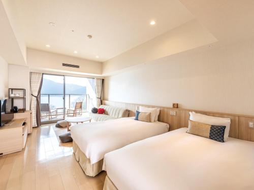 箱根箱根芦之湖花织旅馆(Hakone Ashinoko Hanaori)的酒店客房设有两张床和电视。