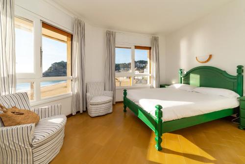滨海托萨Edificio Tropicana的一间卧室设有绿色的床、沙发和窗户。