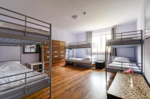 华沙Stara Praga- Dawniej Hostel Krokodyl的客房设有三张双层床和一张桌子。