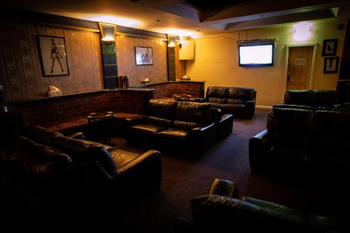 西布罗姆维奇Xtasia Adult Hotel - Adults Only的一间设有真皮沙发和电视的等候室