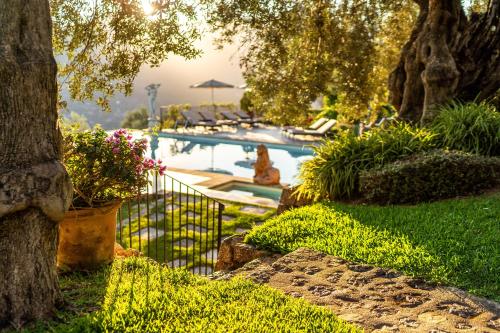 索列尔Ca's Xorc Luxury Retreat - ADULTS ONLY的一座种植了树木和植物的庭院内的游泳池